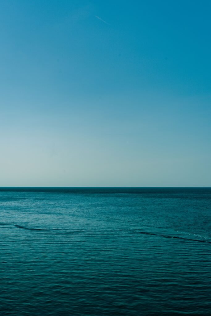 Calm blue waters of the Mediterranean Sea with a clear sky, captured near the Balearic Islands, Spain.
