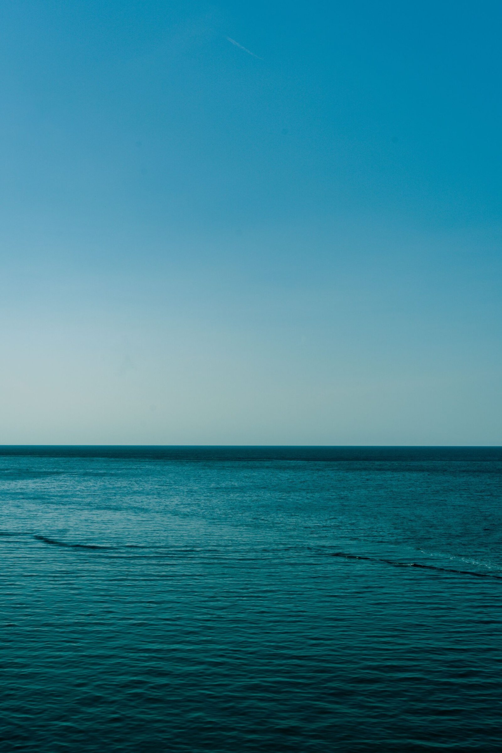 Calm blue waters of the Mediterranean Sea with a clear sky, captured near the Balearic Islands, Spain.
