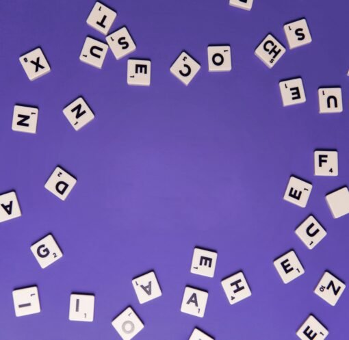 Alphabet tiles scattered on a purple background, perfect for creative projects.