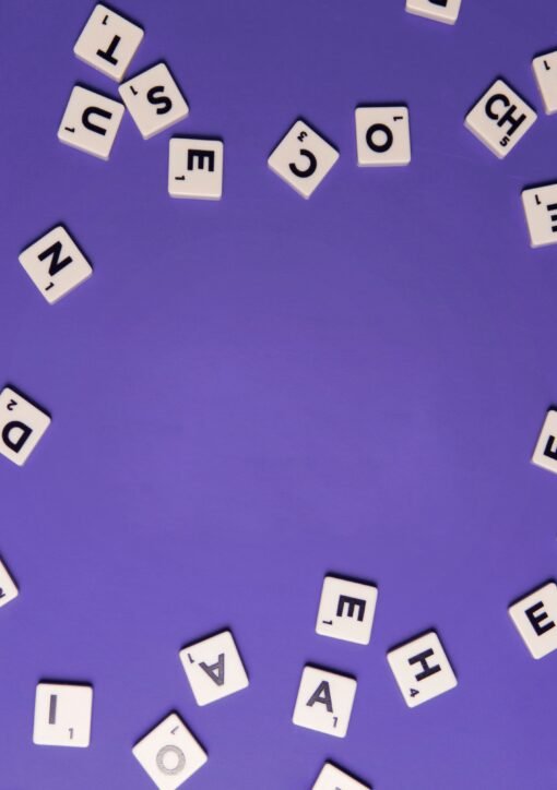 Alphabet tiles scattered on a purple background, perfect for creative projects.