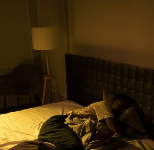 A person sleeping peacefully in a cozy bedroom with soft lighting, creating a serene ambiance.