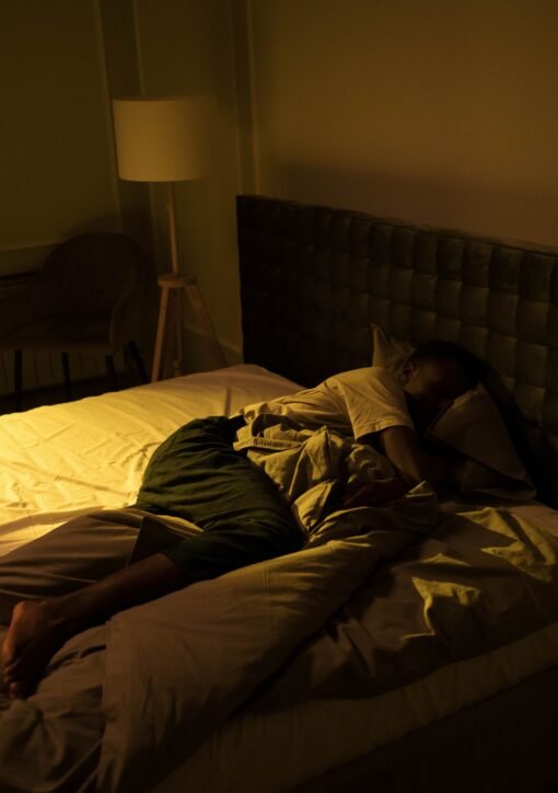 A person sleeping peacefully in a cozy bedroom with soft lighting, creating a serene ambiance.