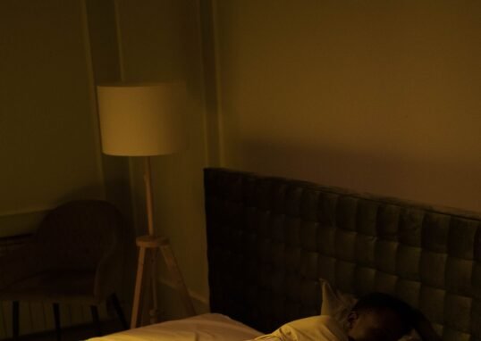 A person sleeping peacefully in a cozy bedroom with soft lighting, creating a serene ambiance.