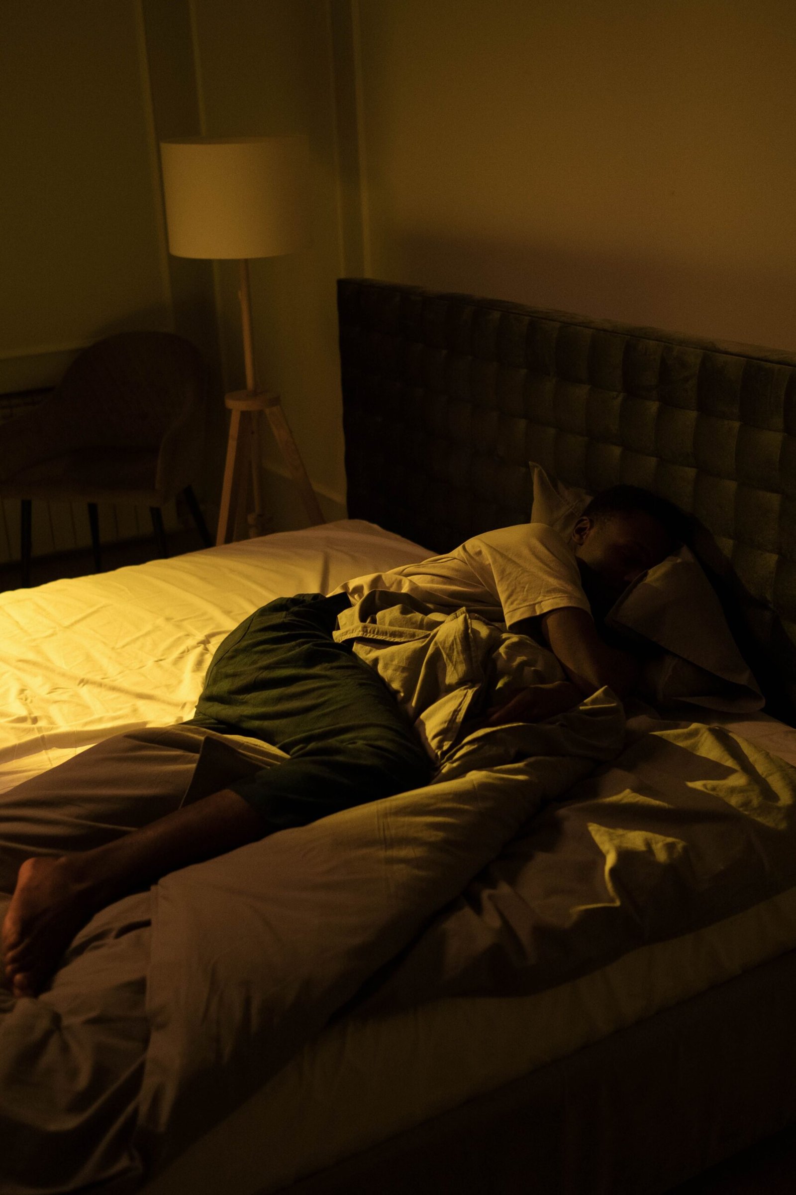 A person sleeping peacefully in a cozy bedroom with soft lighting, creating a serene ambiance.