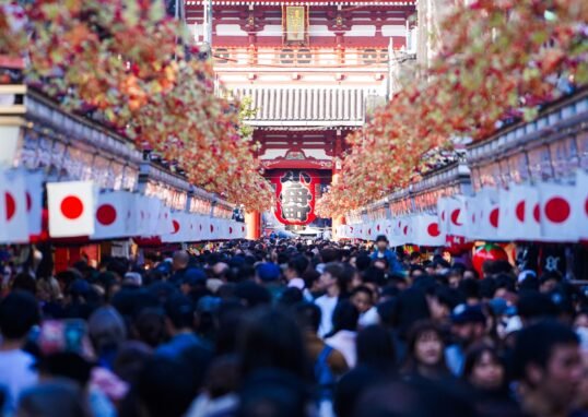 Vibrant crowd at Sensō-ji Temple in Asakusa, Tokyo, during a festive day.