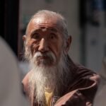 Close-up of a senior man with long beard in a Tokyo street, reflecting tradition and wisdom.