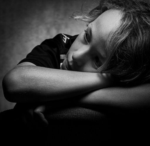 Expressive black and white portrait of a child deep in thought and contemplation.