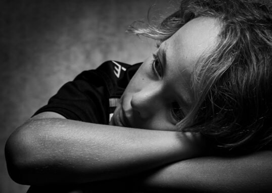 Expressive black and white portrait of a child deep in thought and contemplation.